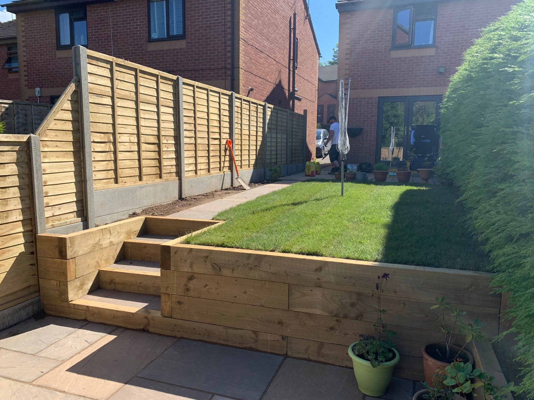 Sleeper retaining wall and steps with new lawn — finished domestic project